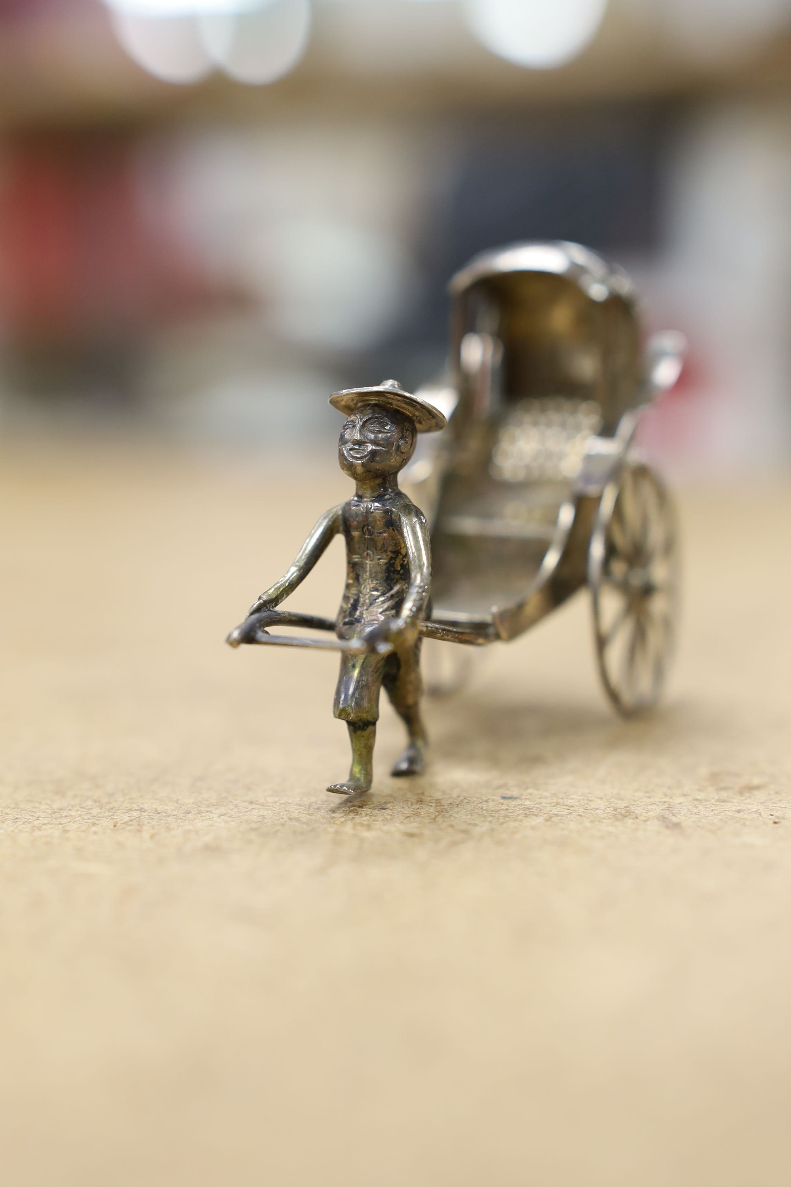 Six assorted miniature white metal items including a Chinese tea kettle on stand (lacking lid), height 93mm, maker CS, a similar rickshaw with driver, maker CH, a Chinese condiment and three other items.